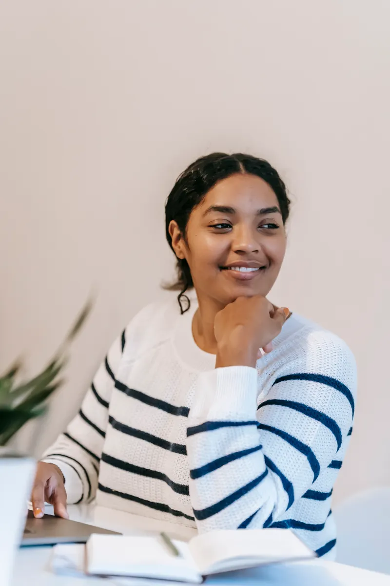 Smiling student sitting at a table with a laptop